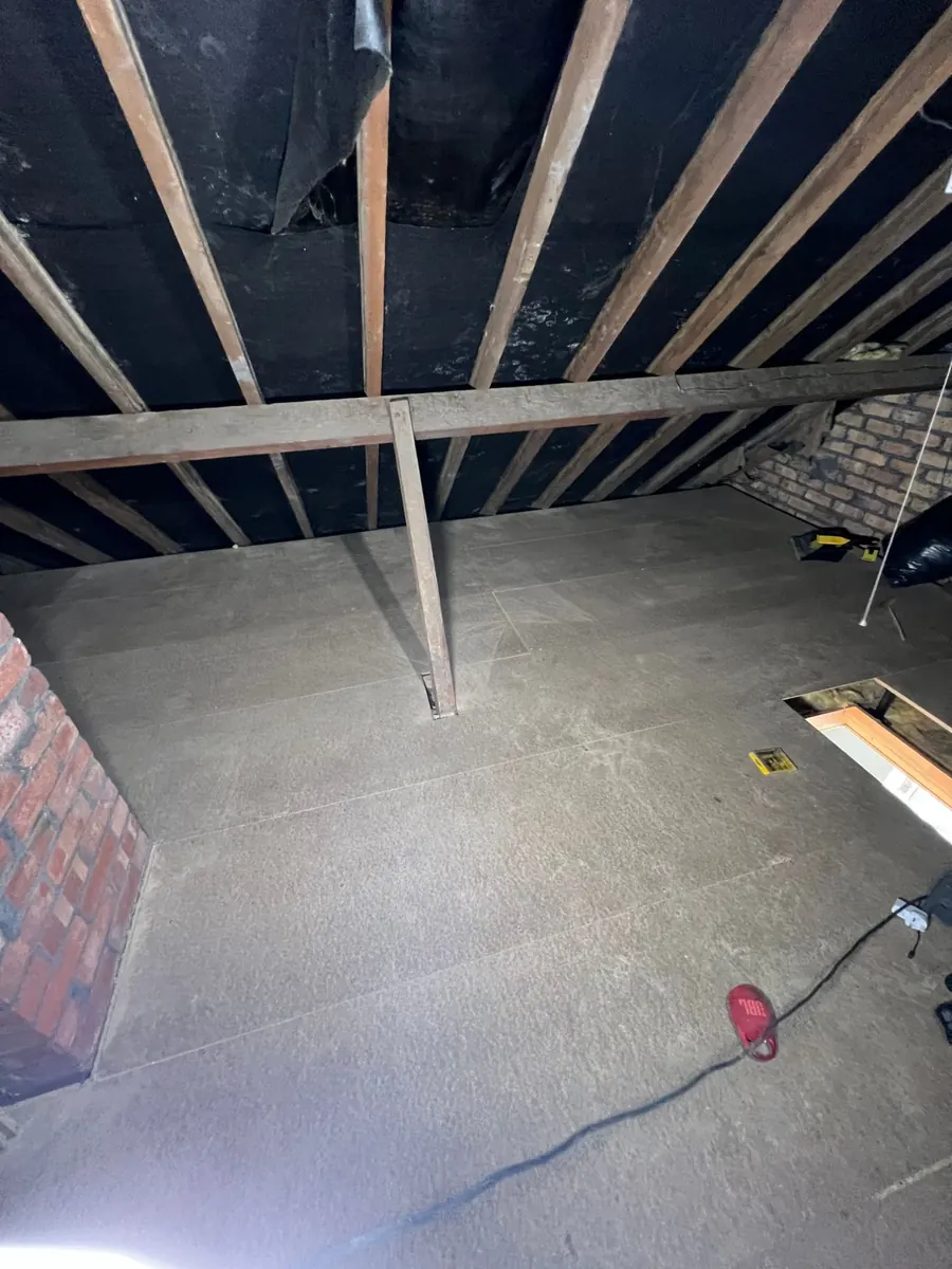 A boarded loft floor with the hatch opening framed in